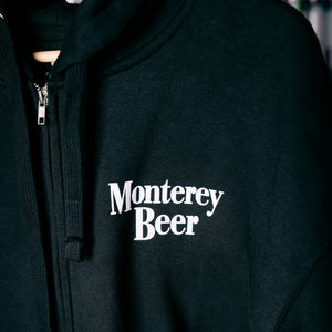 Black hoodie with 'Monterey Beer' text on a dark background